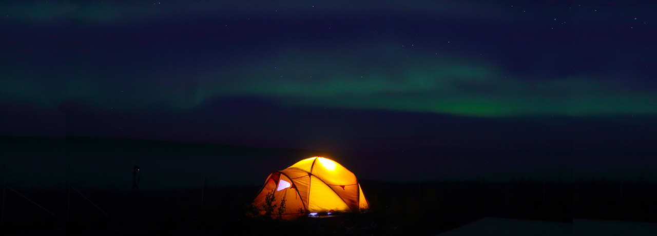 Yellow tent in aurora borealis 