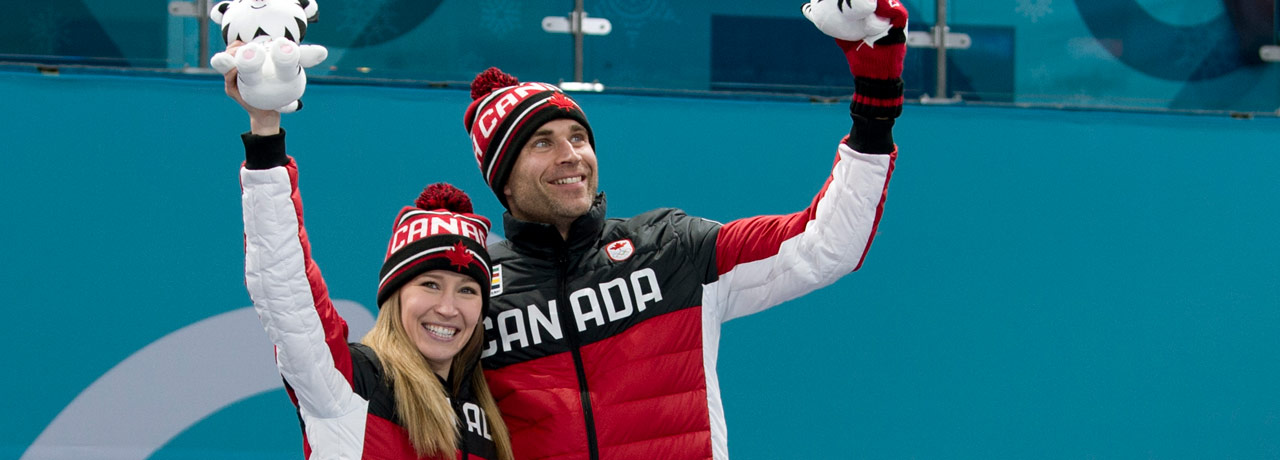 Kaitlyn Lawes and John Morris stand at the podium after winning the gold medal.