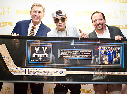 Wayne Zronik presents a signed Maple Leafs hockey stick to Justin Bieber for selling out 2 shows at the Air Canada Centre in 2013.
