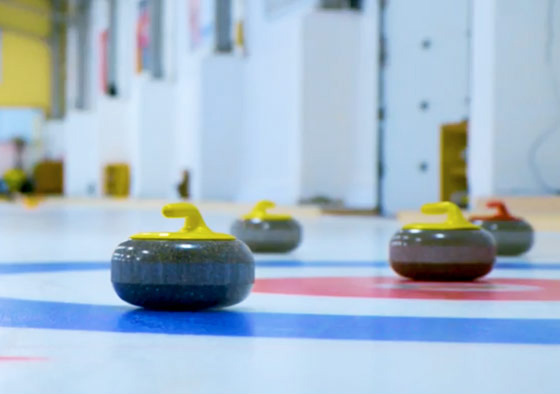 Curling rocks sit motionless on a curling rink.