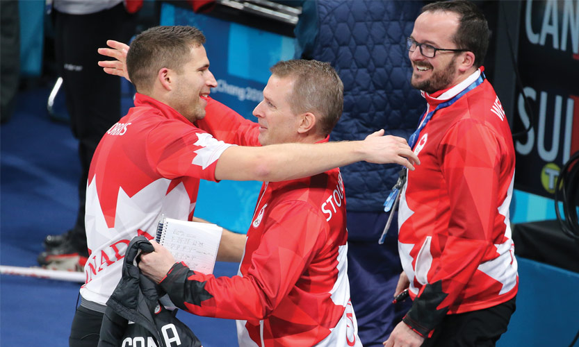 John Morris is congratulated by mixed doubles curling coach Jeff Stoughton as Paul Webster looks on following Morris and Kaitlyn Lawes gold-medal win.